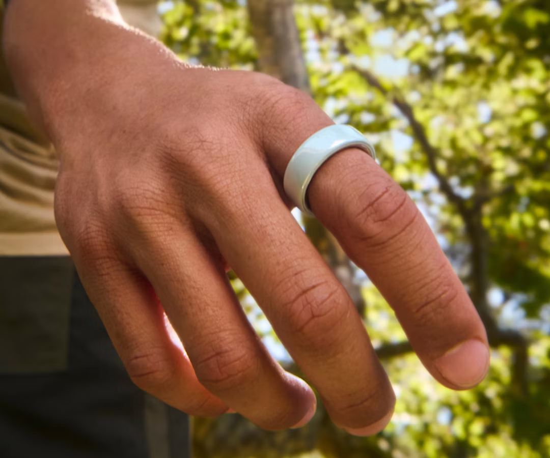 Close up of a person's hand with a Tide Oura Ring 4 Ceramic on their finger